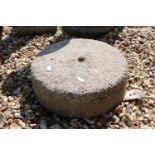 A reconstituted circular stone stand with centre hole.