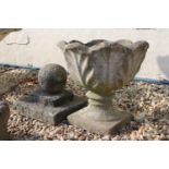 A reconstituted stone garden urn together with a stone finial.