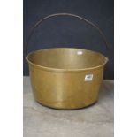 An antique brass jam pan with iron handle.