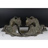 A pair of bronze wall lights in the form of stylized mythical winged creatures with horns.