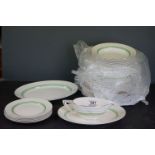 A vintage Wedgwood part dinner service with decorative green pattern.