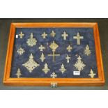 A collection of white metal Christian / Medieval style pendants contained within a wooden glass