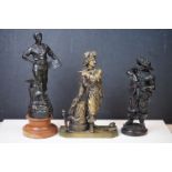 A collection of three spelter figures together with a brass example.