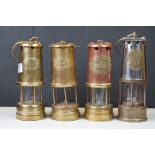 A collection of four miners lamps to include brass and copper examples.