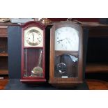 A vintage wooden cased wall clock together with a contemporary example.