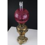Victorian Aesthetic Movement Brass Oil Lamp with Cranberry Globular Glass Shade, 59cms high