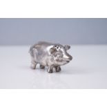 A white metal Pounce in the form of a pig.
