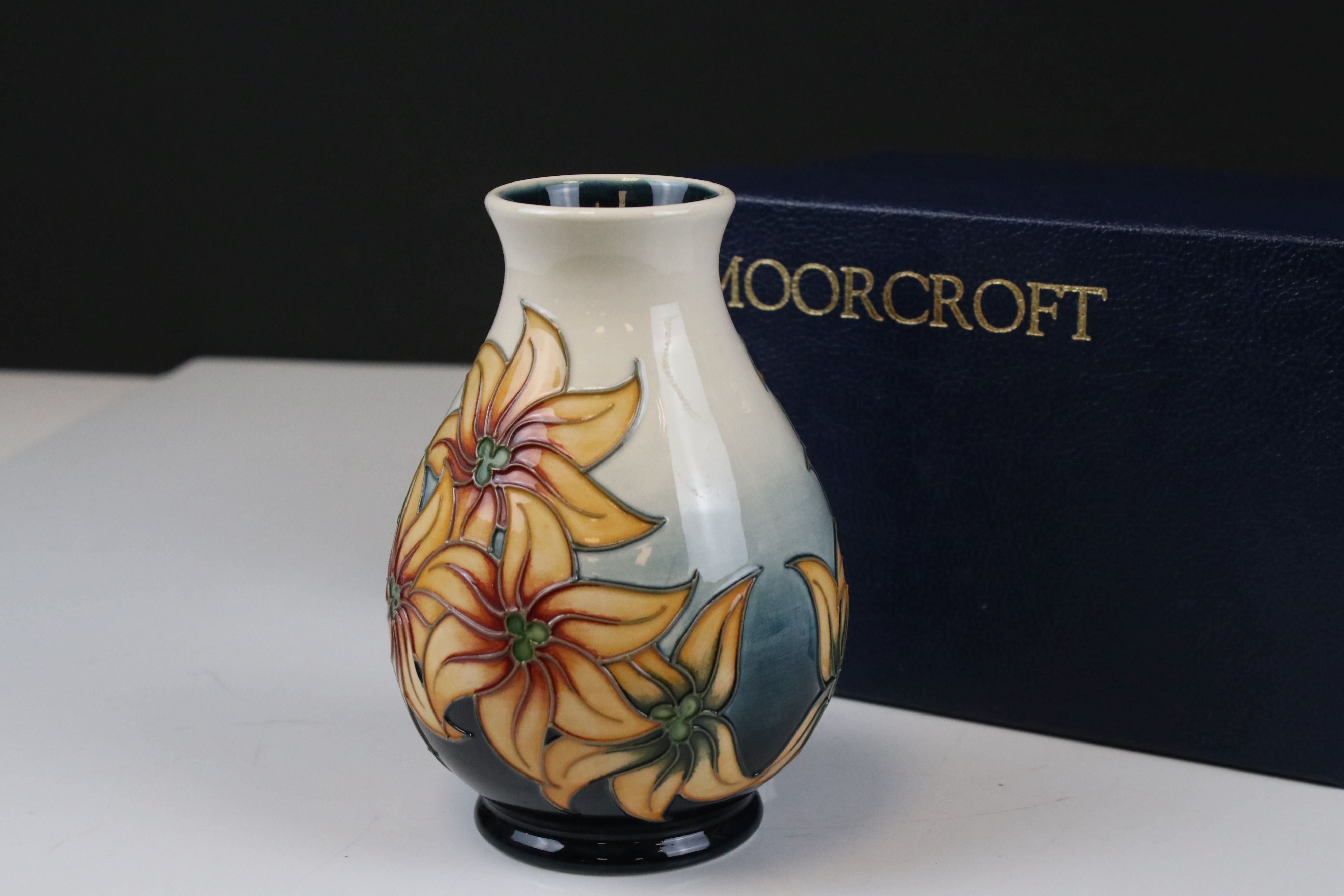 Moorcroft Vase decorated with Orange Flowers on a White and Teal ground., 14cms high, boxed