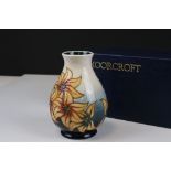 Moorcroft Vase decorated with Orange Flowers on a White and Teal ground., 14cms high, boxed