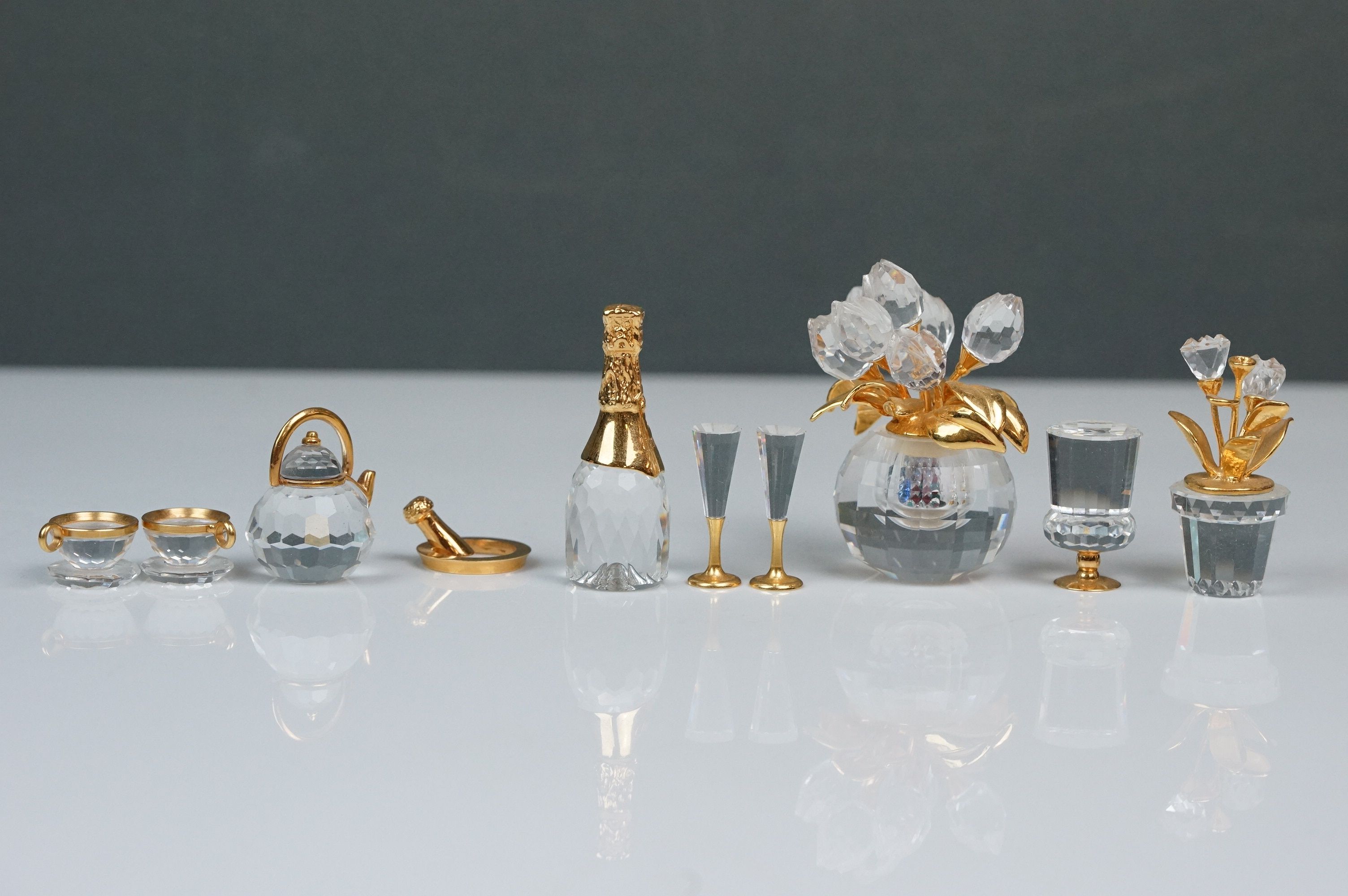 Nine Swarovski Crystal miniatures, comprising champagne bottle, two champagne flutes, teapot with