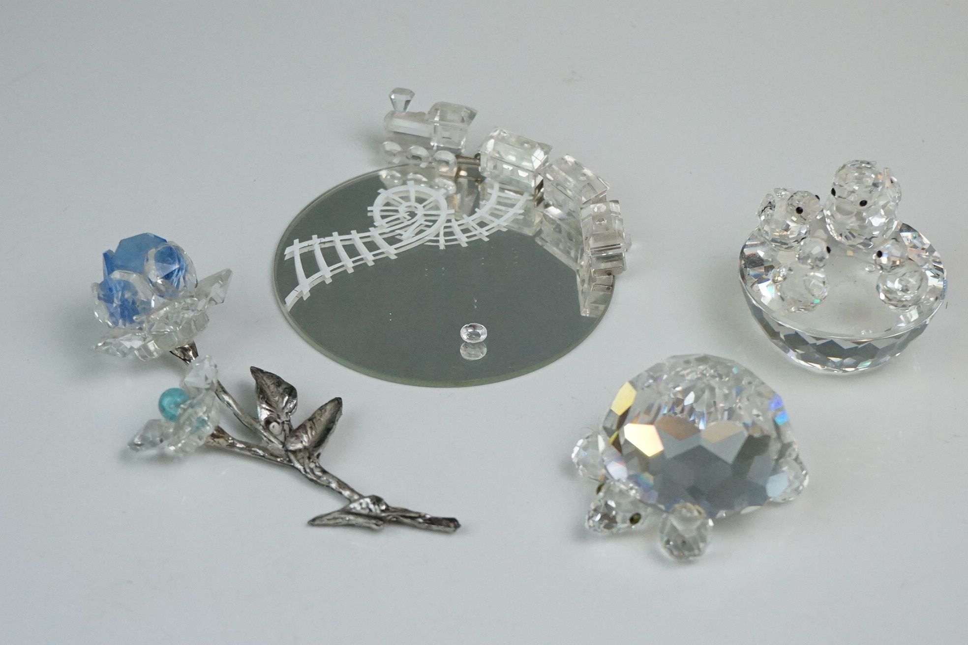 Swarovski crystal figurines comprising miniature train and carriages on mirrored stand; flower