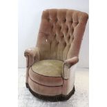 Early 20th century Pink Button Back Upholstered Armchair with circular seat and fringed apron,