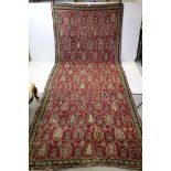 Eastern Wool Red Ground Rug with stylised pattern, approx. 137cms x 350cms