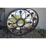 A pair of wrought iron circular decorative mirrors.