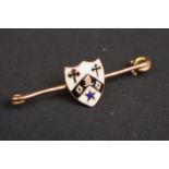 A fully hallmarked 9ct gold bar brooch with decorative enamel shield.