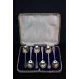 A cased set of six fully hallmarked sterling silver tea spoons with crossed golf clubs on the