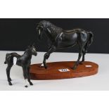 A Beswick matt black stallion on wooden plinth together with a Beswick black foal.