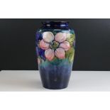 Walter Moorcroft Vase in the Clematis pattern on blue / green ground, marked to base with a