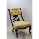 Victorian Mahogany Low Salon Chair upholstered in yellow buttoned fabric with ornately carved