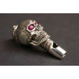 Silver skull shaped whistle with red eyes