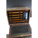 A vintage wooden engineers cabinet with internal drawers, complete with contents.