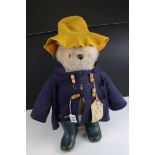 A vintage Gabrielle Paddington bear with blue duffle coat and green dunlop boots.