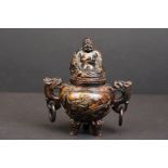 An oriental sensor with dragon handles and happy Buddha to the lid.