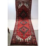 Large red ground handwoven Persian village runner, medallion design, approx. 292cm x 97cm