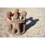 A vintage terracotta garden ornament of four figures in a ring.