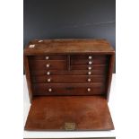 A vintage wooden engineers cabinet with internal drawers, complete with contents.