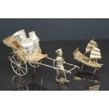 A Chinese white metal cruet set in the form of a rickshaw together with a white metal junk boat.