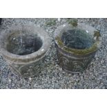 A pair of reconstituted stone decorative garden planters.