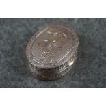 A small sterling silver pill box with engraved floral decoration.