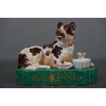 19th century ceramic inkwell and pen stand in the form of a recumbent dog on a plinth