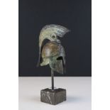 A miniature metal sculpture of a Roman Centurion helmet.