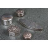 A collection of five white metal pill boxes.