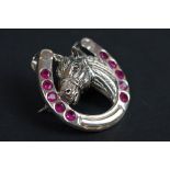 Silver horse shoe brooch set with rubies