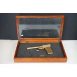 A scratch built model of the James Bond golden gun contained within display case.