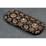 A vintage decorative glasses case with gold thread decoration.