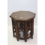 Indian Hardwood Octagonal Table , the top with foliate brass inlay, raised on a folding carved base,