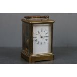 A vintage brass cased carriage clock with white enamel dial.
