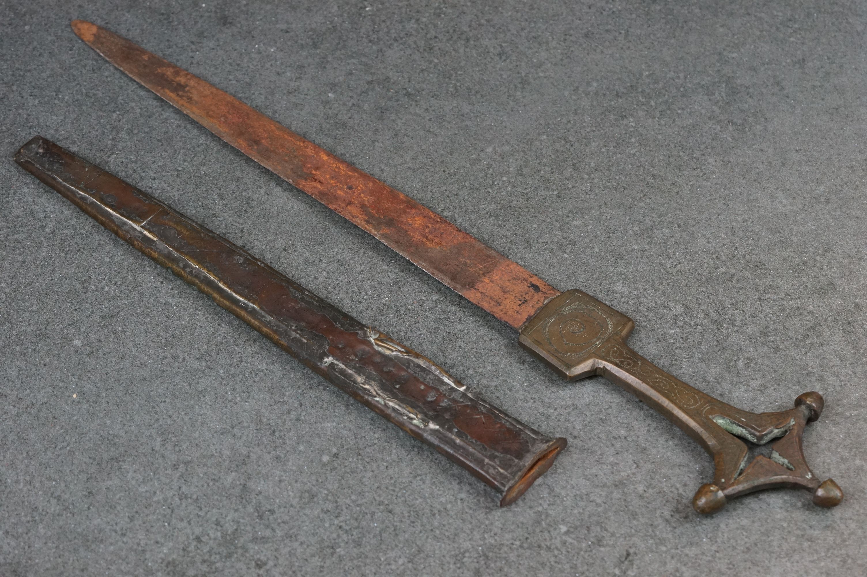 A vintage ceremonial dagger within decorative brass sheath.