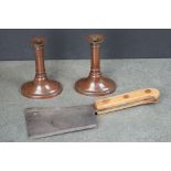 A pair of antique copper candlesticks together with a meat cleaver.