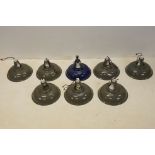 A collection of eight enamel industrial light fittings.