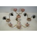 Set of three pink ground floral decorated ceramic and reeded brass twin branch wall lights, together