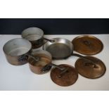 A set of vintage graduated copper pans with lids.