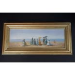 Gilt framed oil painting of a Victorian beach with ladies holding parasols
