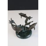 Bronze sculpture of three dolphins mounted on a granite base