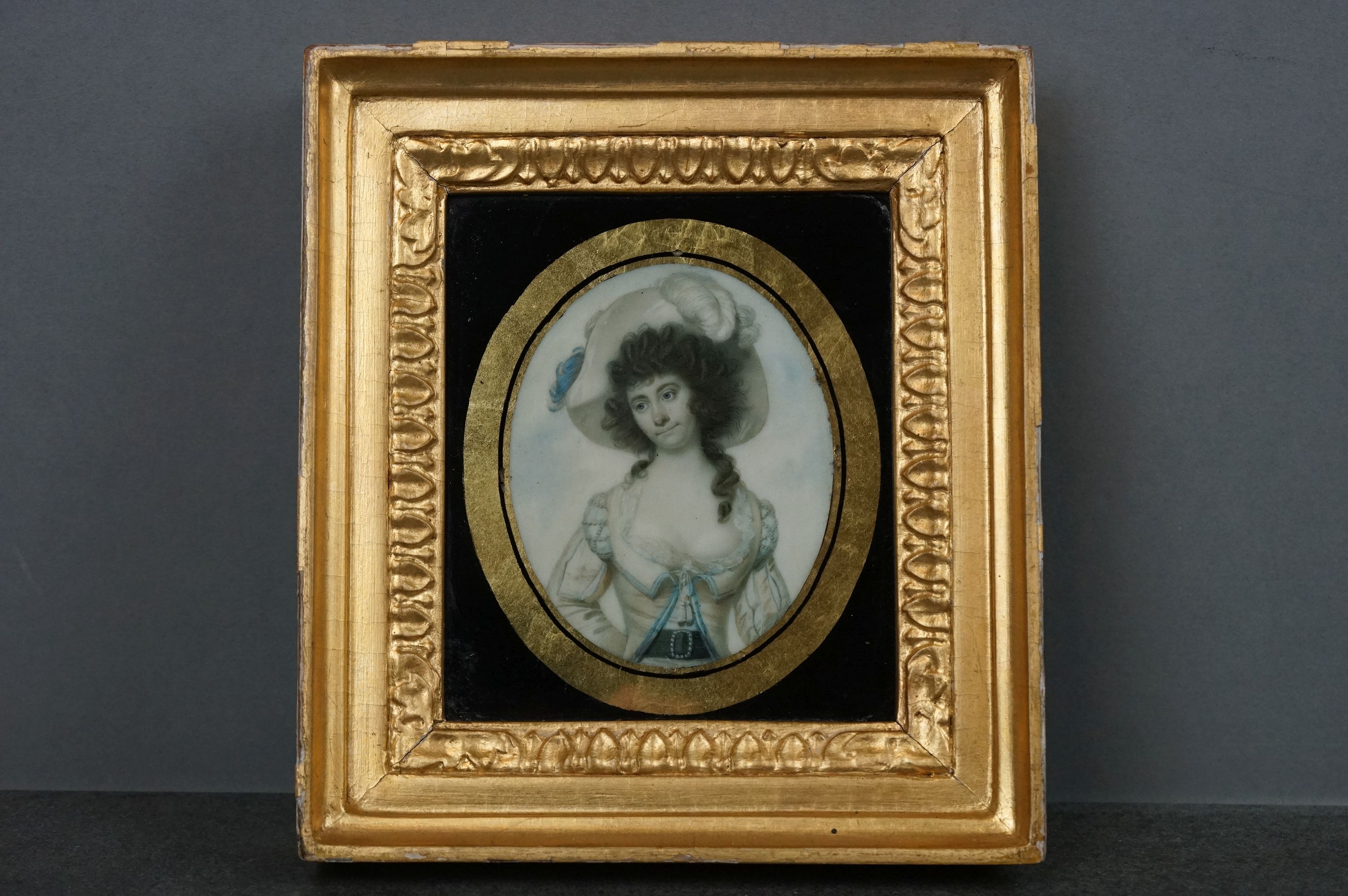 A hand painted miniature portrait of a lady within a gilt frame.