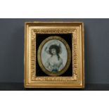 A hand painted miniature portrait of a lady within a gilt frame.